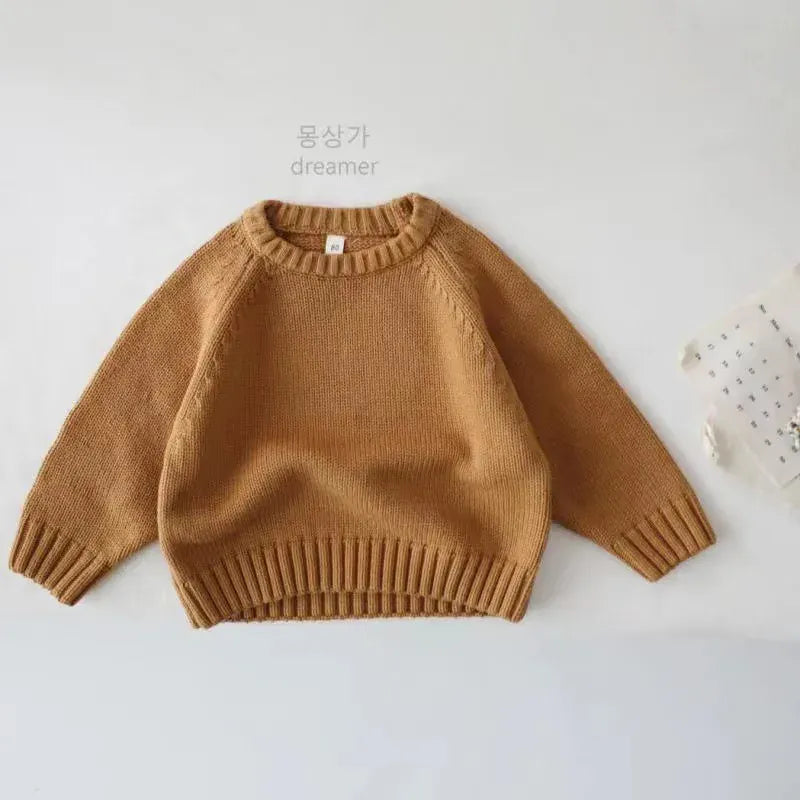 キッズ用ニットセーター(キャメル系)。リブ編みの首元と袖口、裾のフリル風ライン。