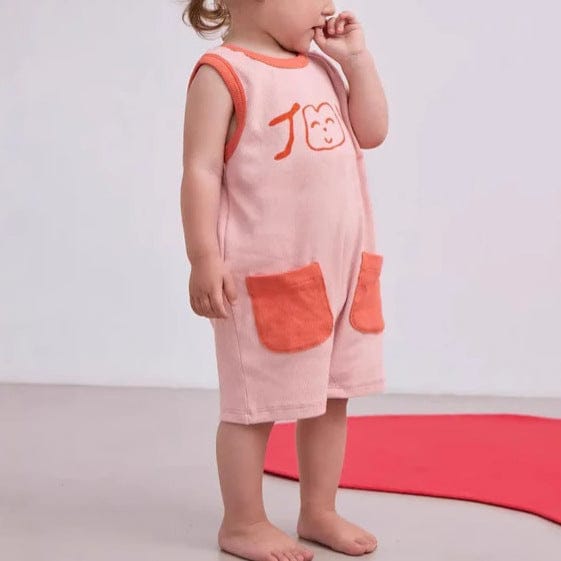 ピンクのノースリーブロンパース、オレンジの縁とポケット、前プリント