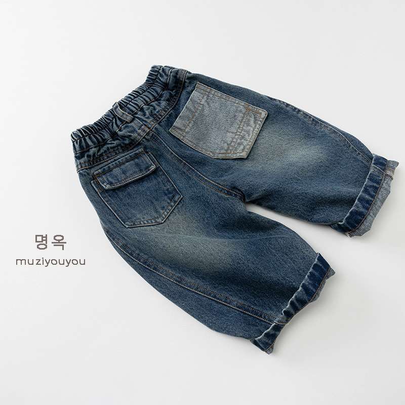 ダークブルーのデニムパンツ、背面寄り、伸縮ウエストとフラップ付きポケット
