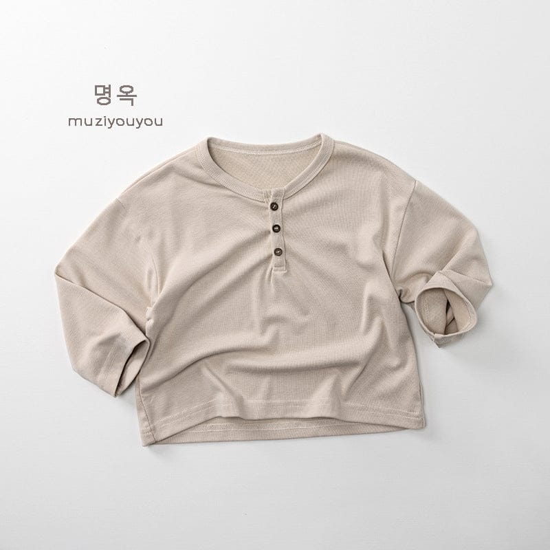 ベージュ系の長袖ヘンリーネックTシャツ、ボタン付き