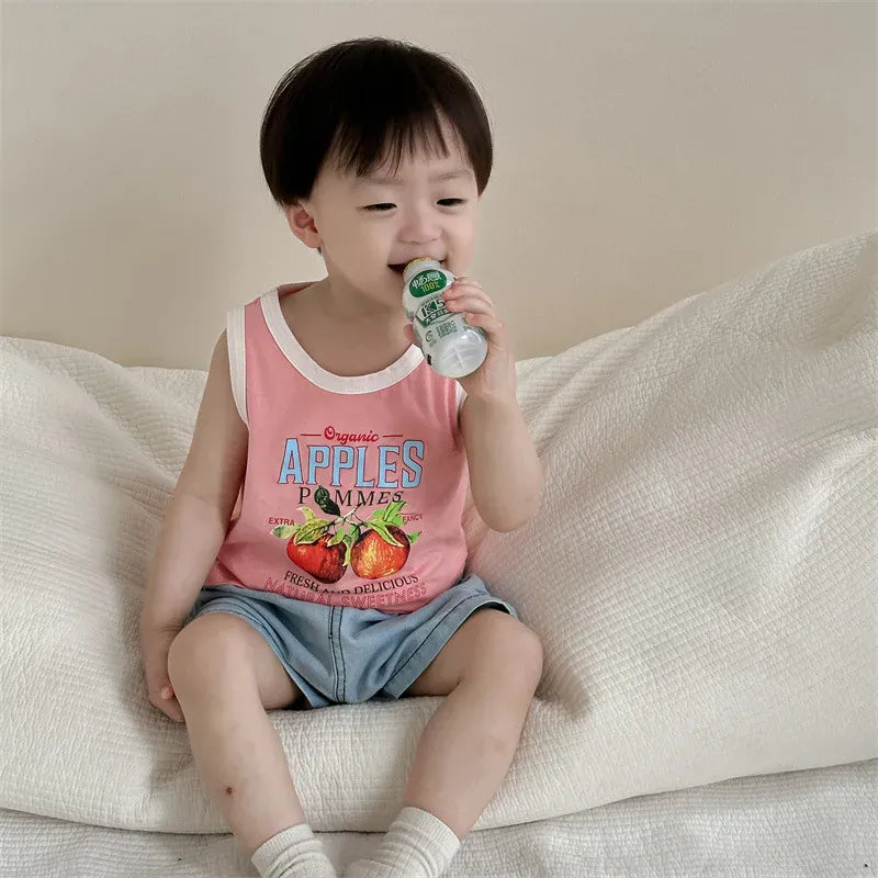 ピンクのベビータンクトップとデニムショートパンツ。飲み物を持つ姿