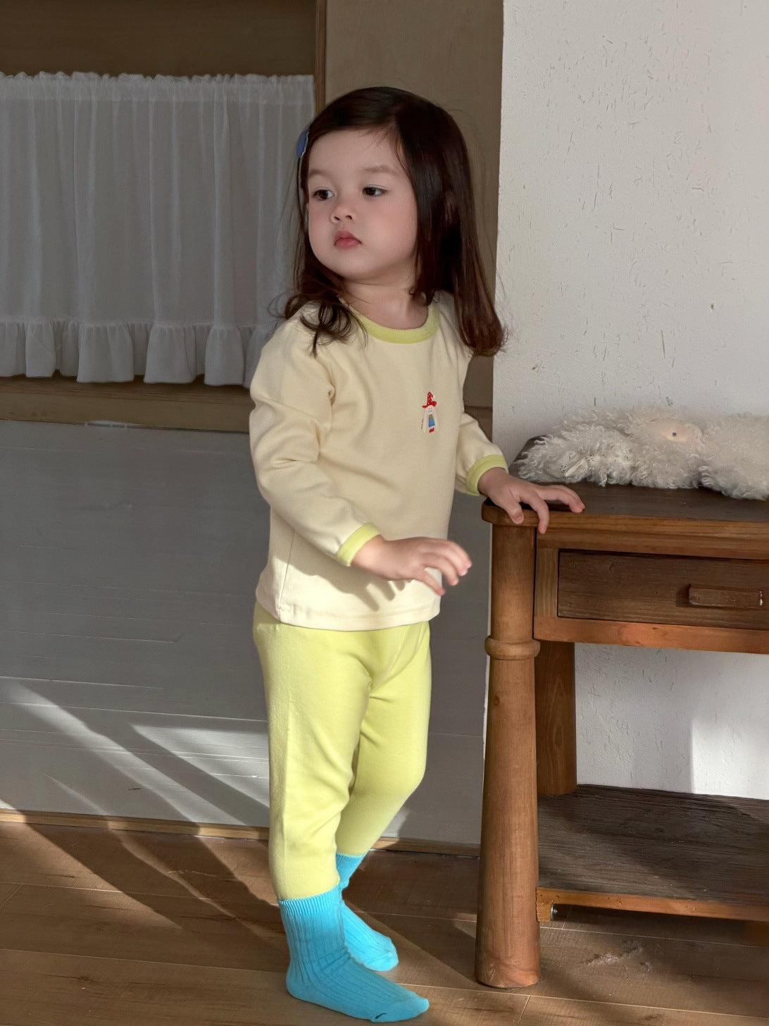 淡いイエローの長袖パジャマ上下セット、胸に小さなプリントと配色リブ