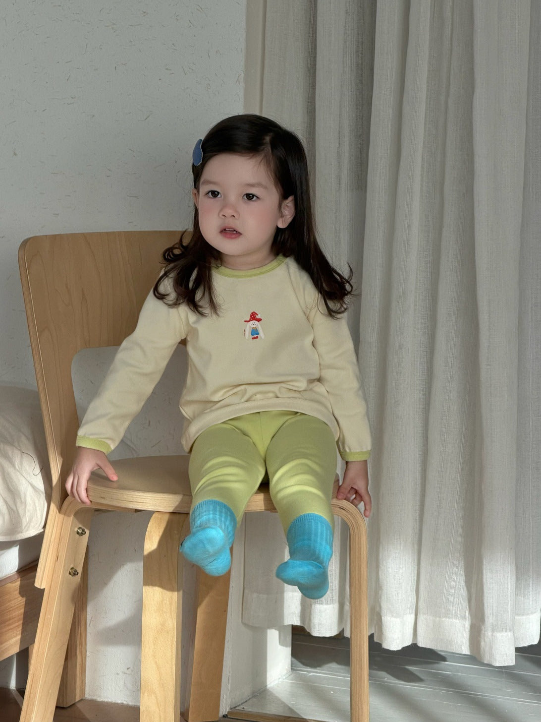 子ども用プリント長袖パジャマセット 黄色系 座った姿勢の長袖トップとパンツ