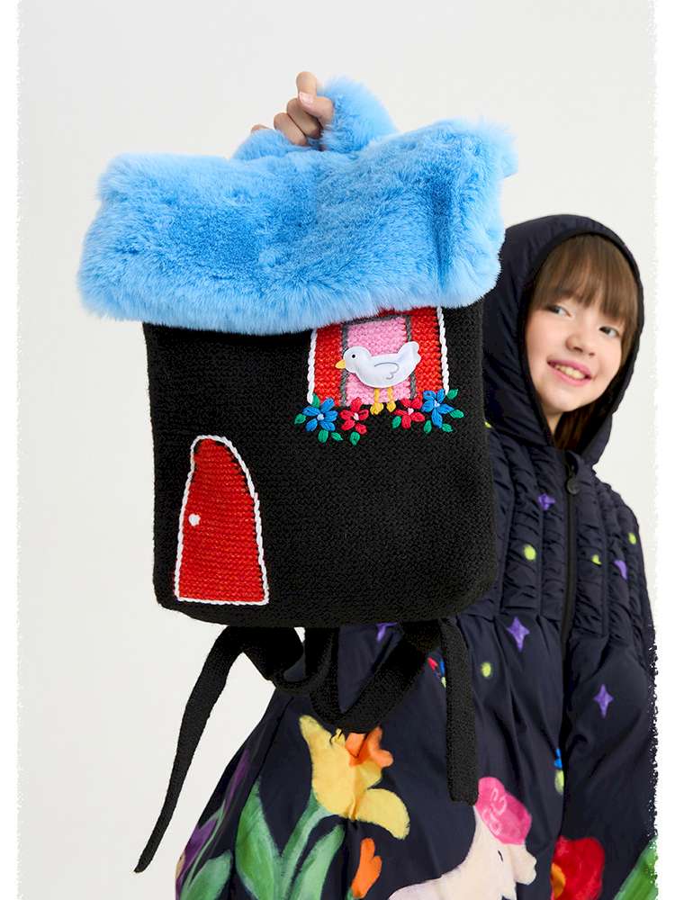 黒のロングダウンコート。青いファーの上に動物モチーフのアップリケ