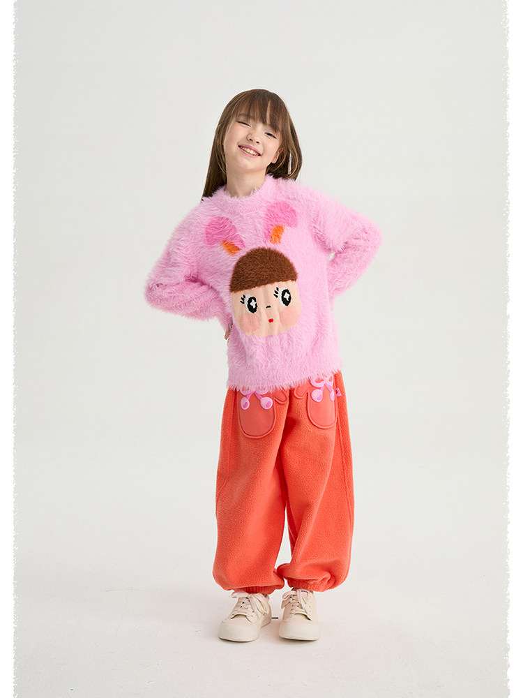 ピンクのシャギー風セーター、前面にキャラクター顔のジャカード風デザイン