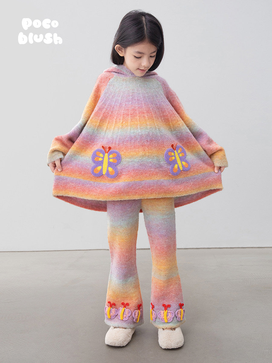 レインボーのフード付きニットポンチョとフレアパンツ、蝶の刺繍と裾の装飾