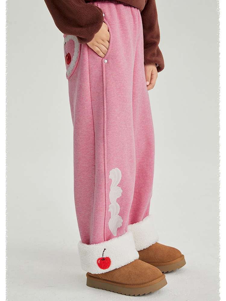 ピンクの裏起毛ワイドパンツ、側面にチェリー模様の切替と丸い白ボタン