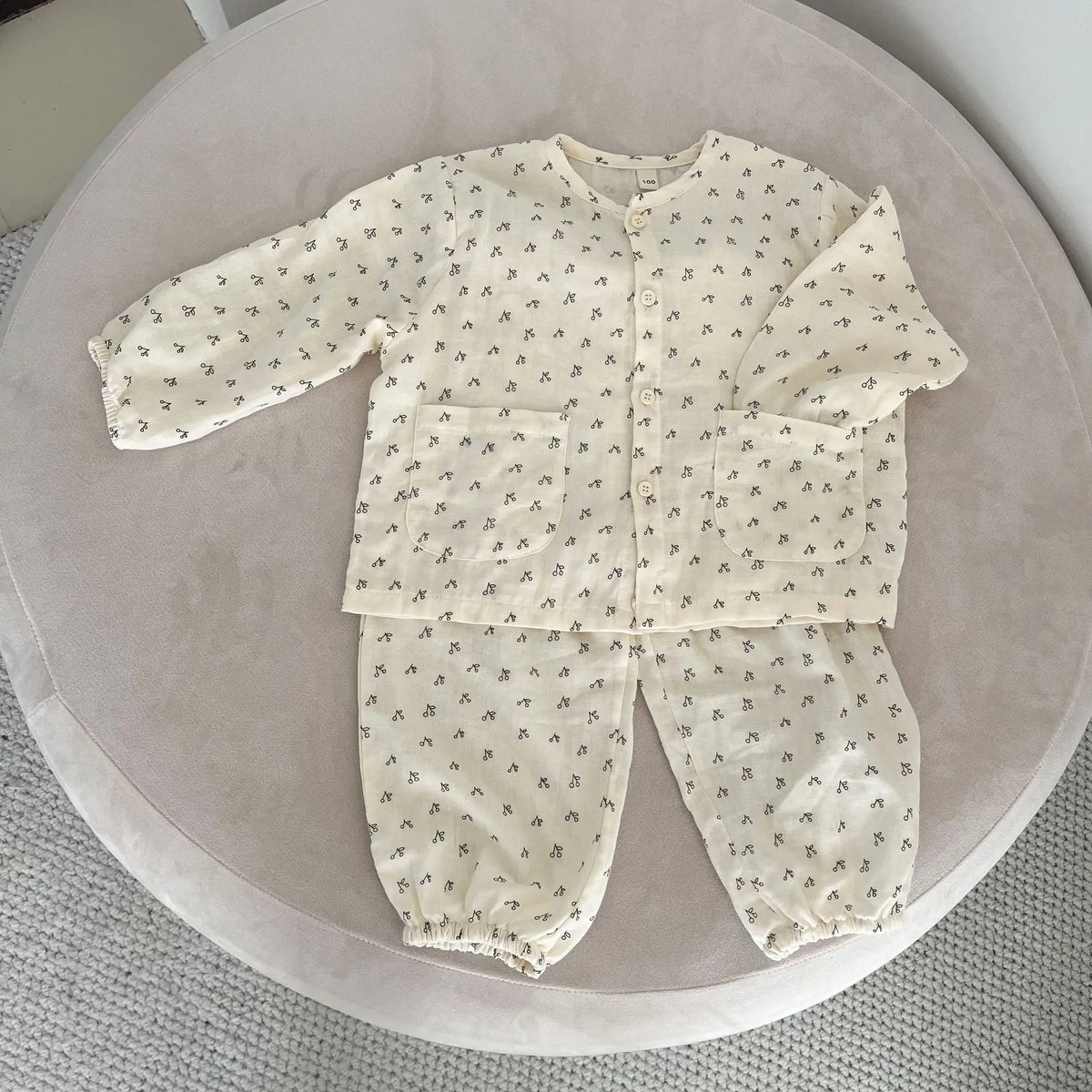 子ども用パジャマ2点セット、淡いアイボリー総柄の長袖トップスと長ズボン