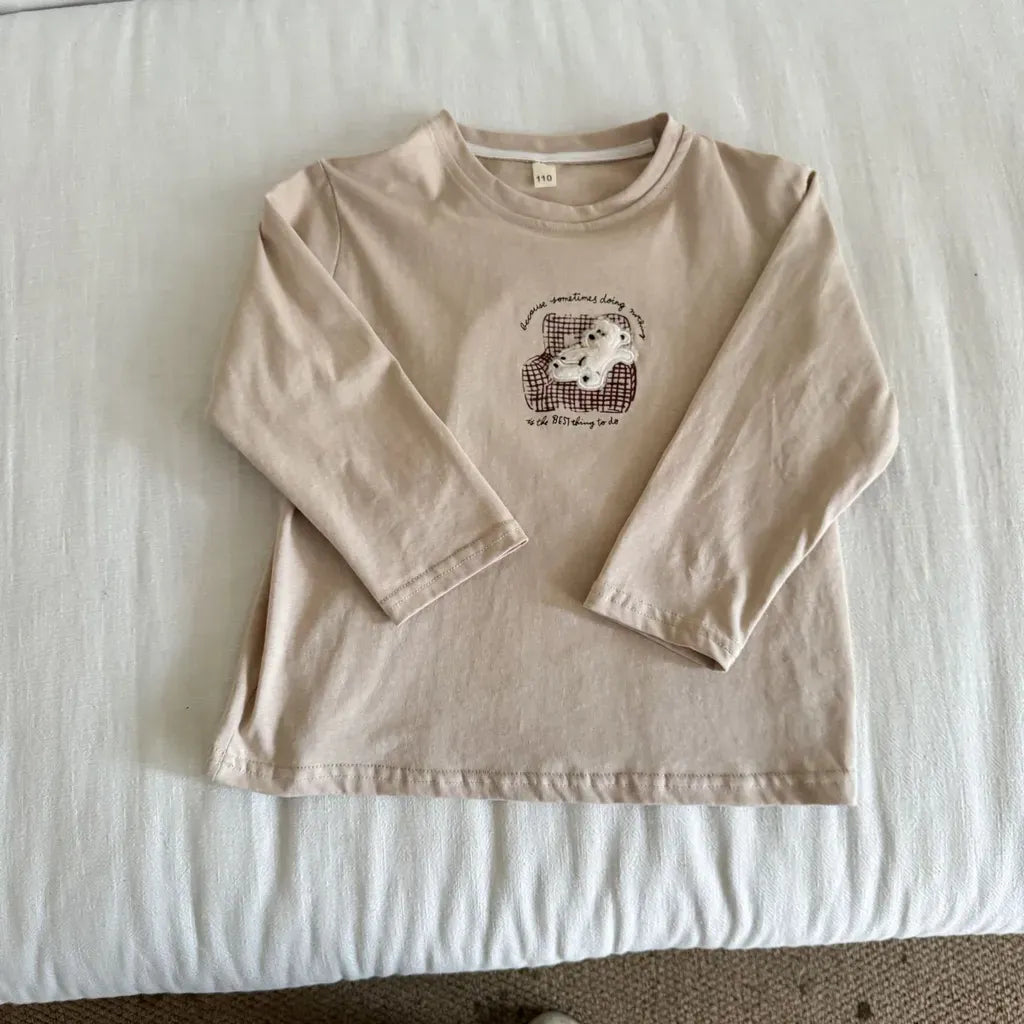 生成り色長袖Tシャツ、胸元に刺繍デザインのシンプルなクルーネック