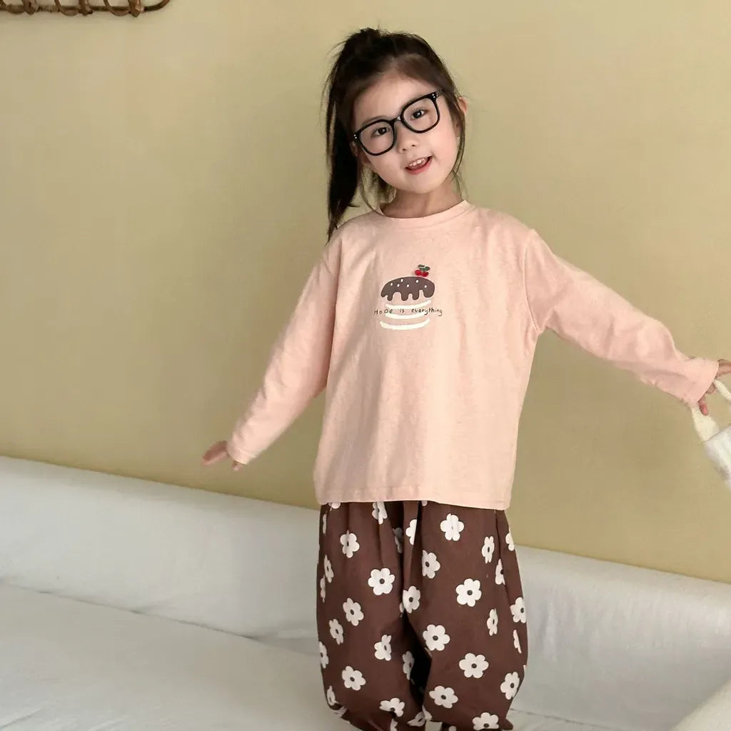 ピンク系長袖Tシャツ、胸元の刺繍デザインが見えるラウンドネック