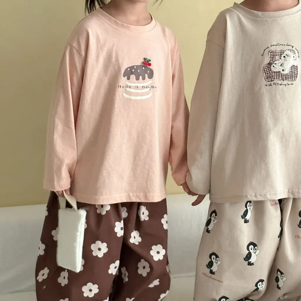ピンクの長袖Tシャツ、フロントに刺繍風デザインとラウンドネック