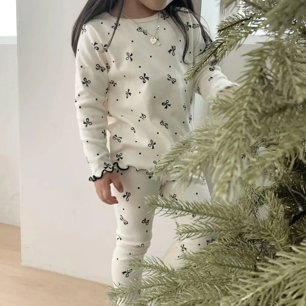 リボン柄プリントの子ども用パジャマ、丸首長袖トップスとロングパンツ