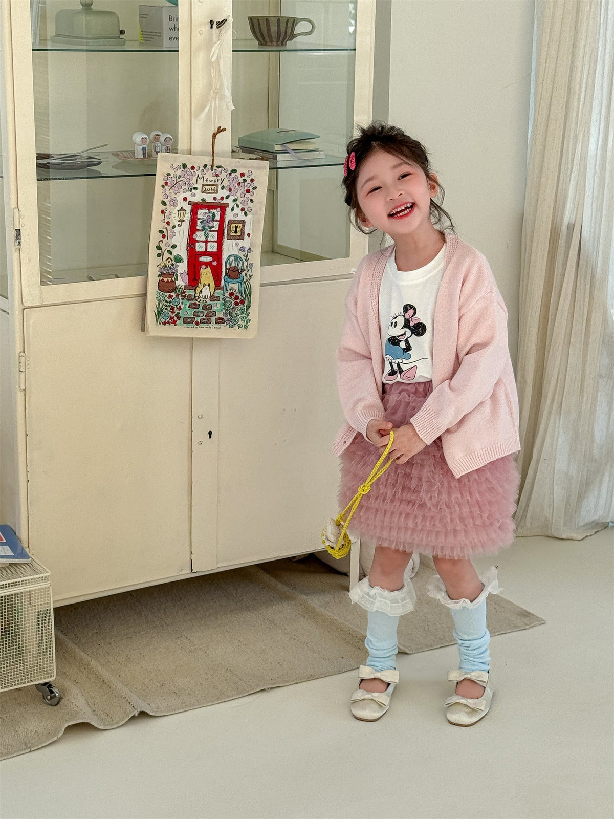 ピンクVネックの子ども用長袖カーディガン、シェルボタン付き