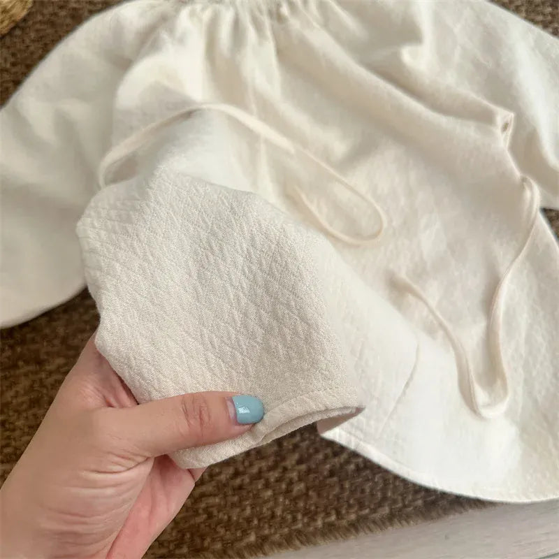 キッズ用ワンピース前身頃アップ。ベージュ系の立体切替と丸い装飾。