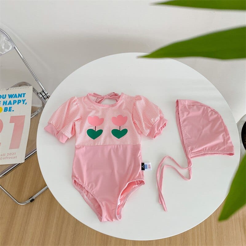 ピンクのキッズ水着ワンピース、パフスリーブ&ハート柄、同系色の帽子付き