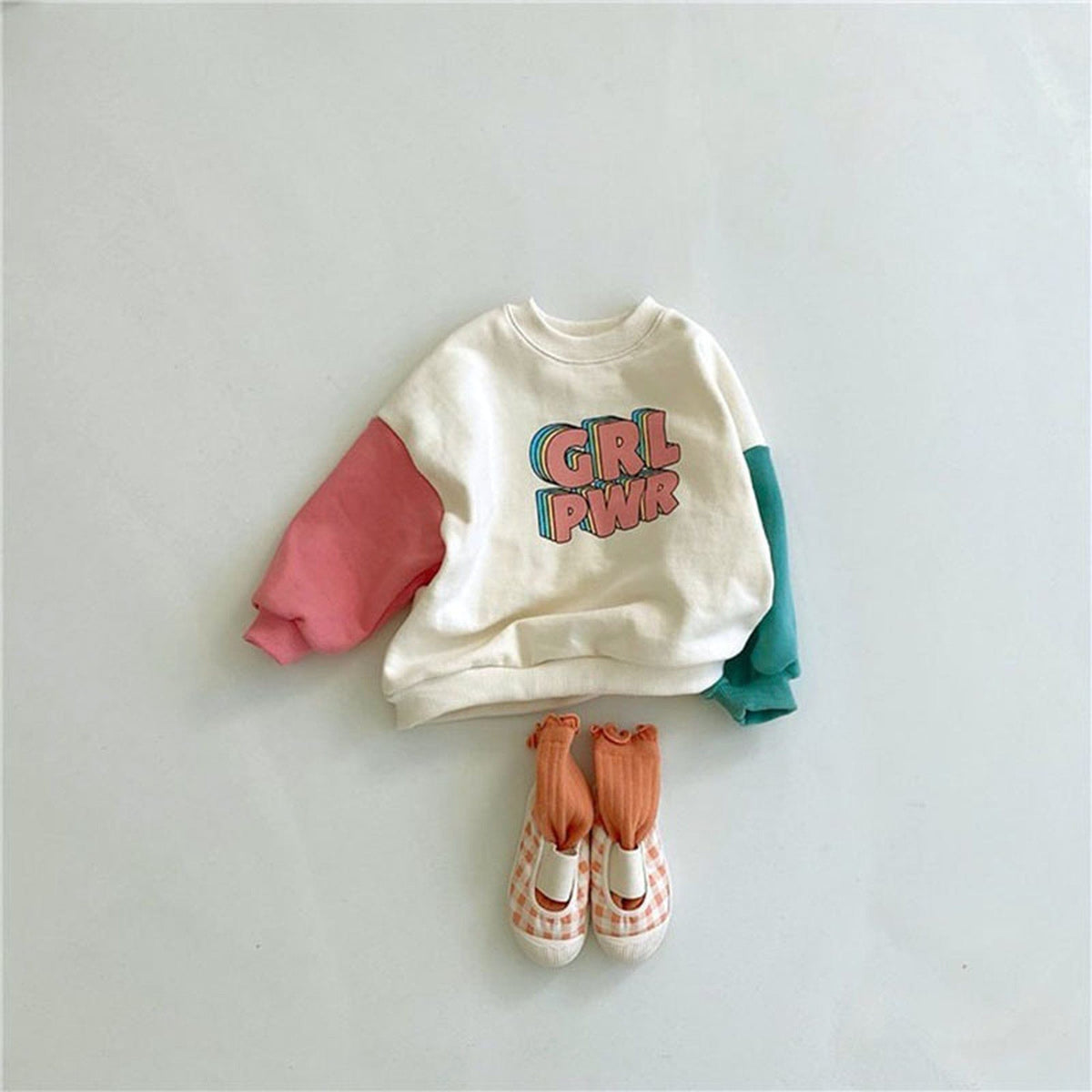 白ベースのベビー長袖ロンパース「GRL PWR」プリント、袖バイカラー