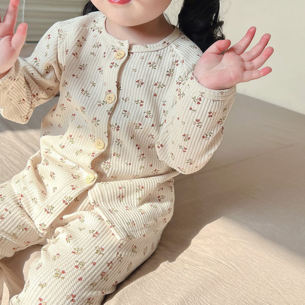 子どもが着用するキッズ長袖パジャマ、ベージュ地の小花プリント