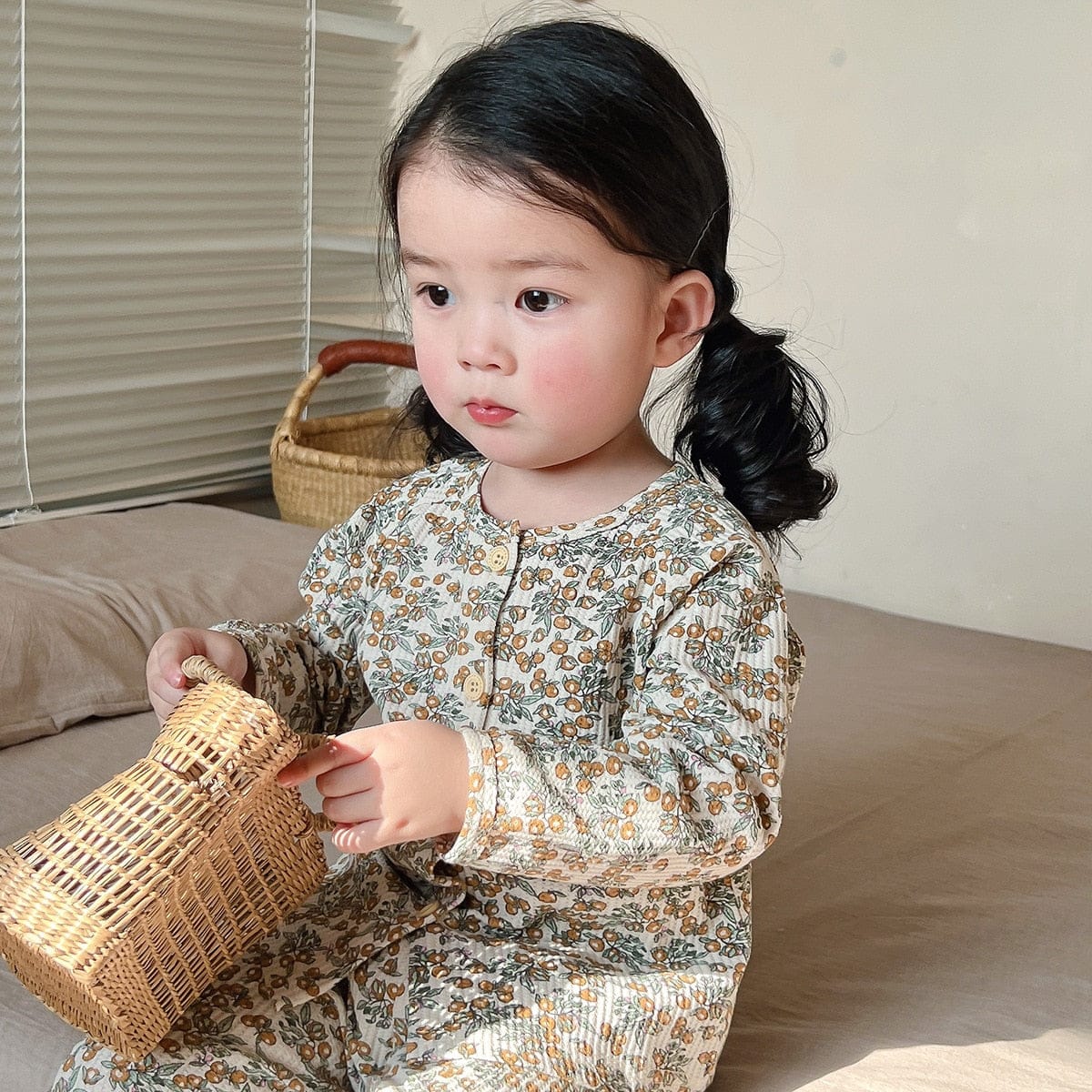 キッズ長袖パジャマを着た子ども、ベージュ地の小花総柄上下セット