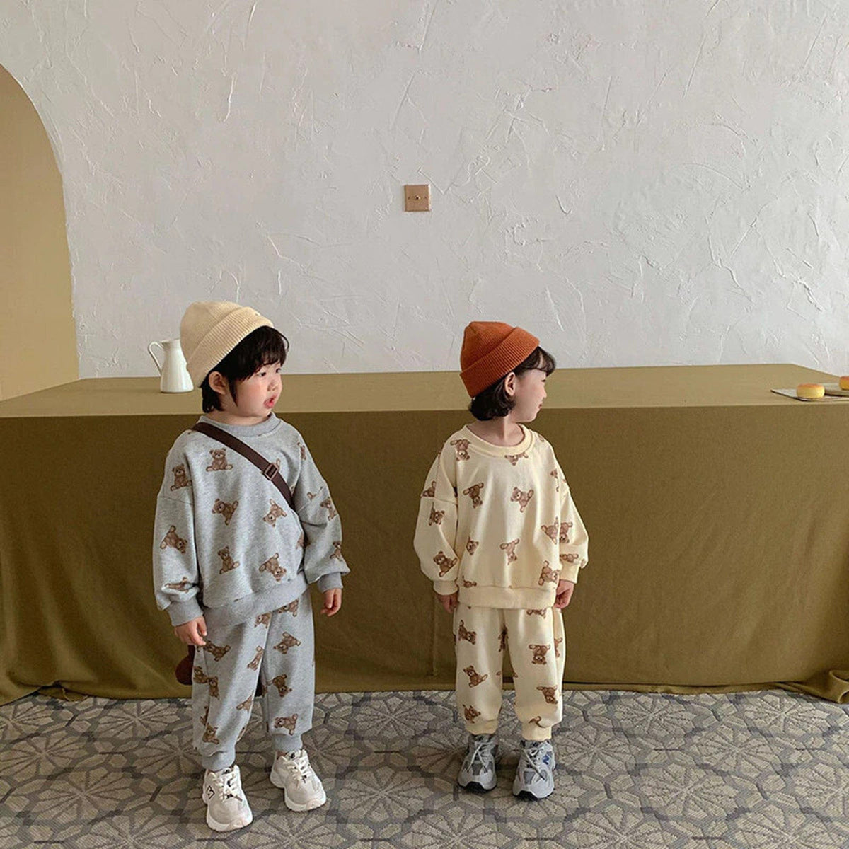 くま柄トレーナー&スウェットパンツを着た子ども2人(グレー/ベージュ)