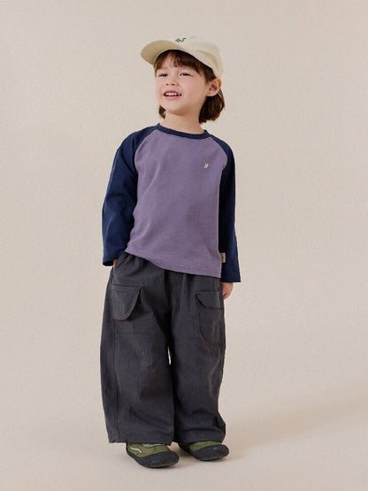 ベージュのキッズキャップをかぶった子ども、フロント刺繍ロゴ