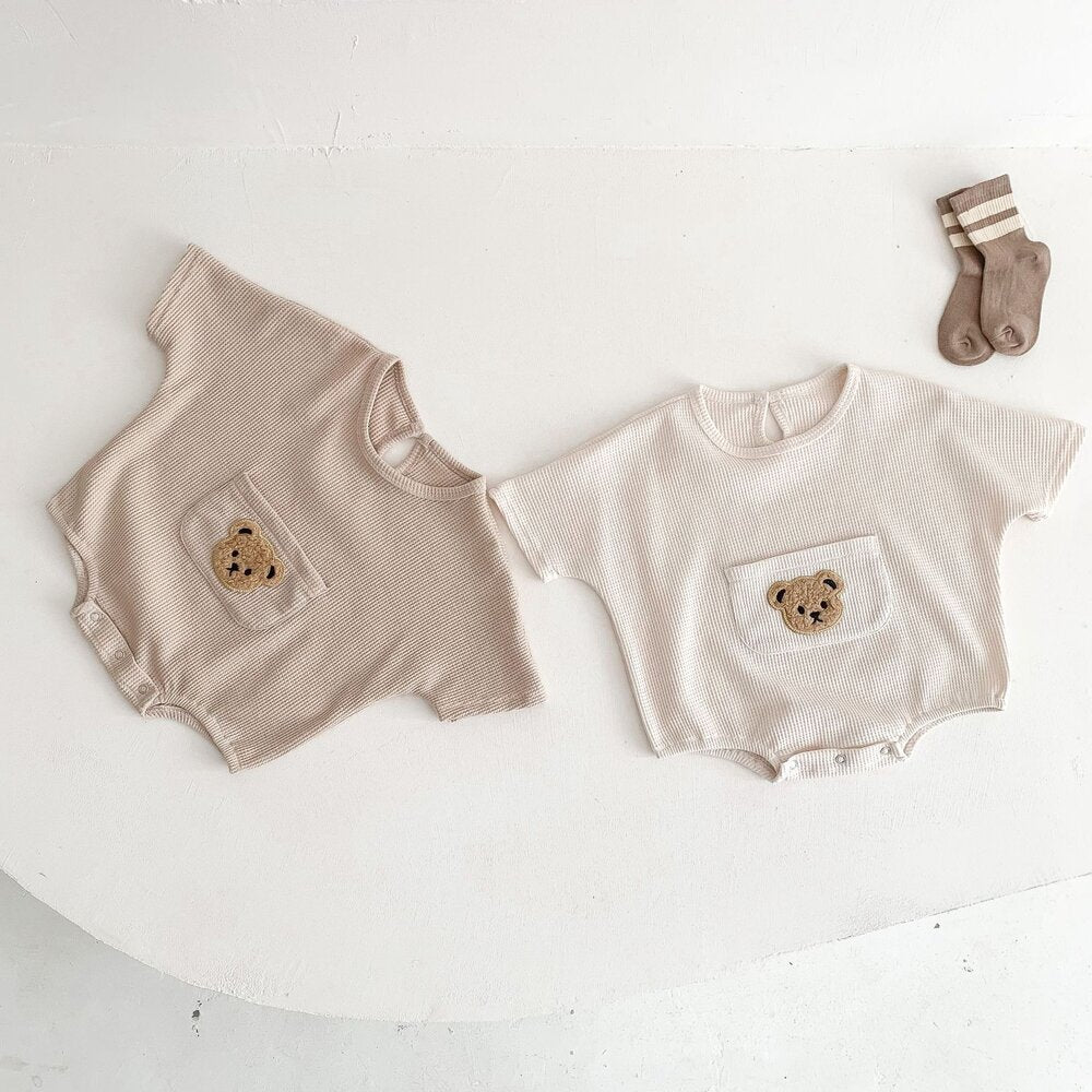 ベージュ系と白のワッフル半袖ロンパース2枚、各前ポケットにクマ刺繍