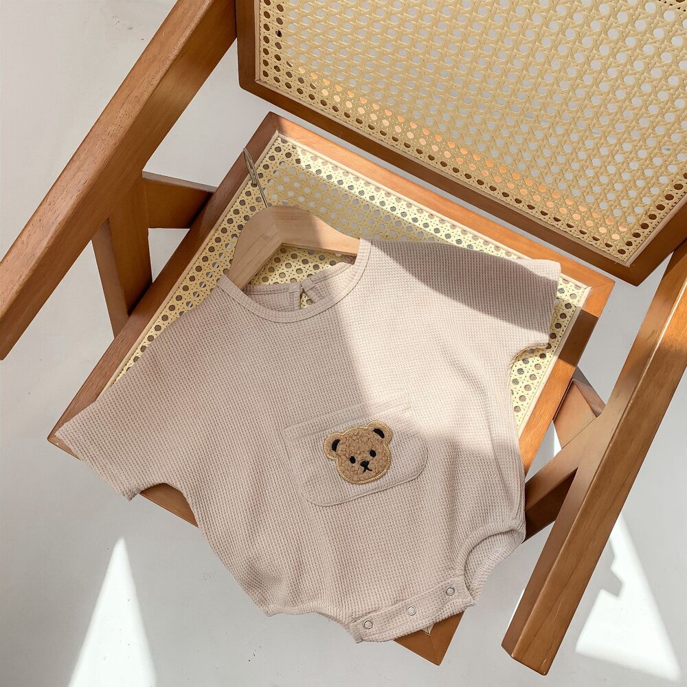 ベージュのワッフル半袖ロンパース、前ポケットにクマ刺繍のアップ