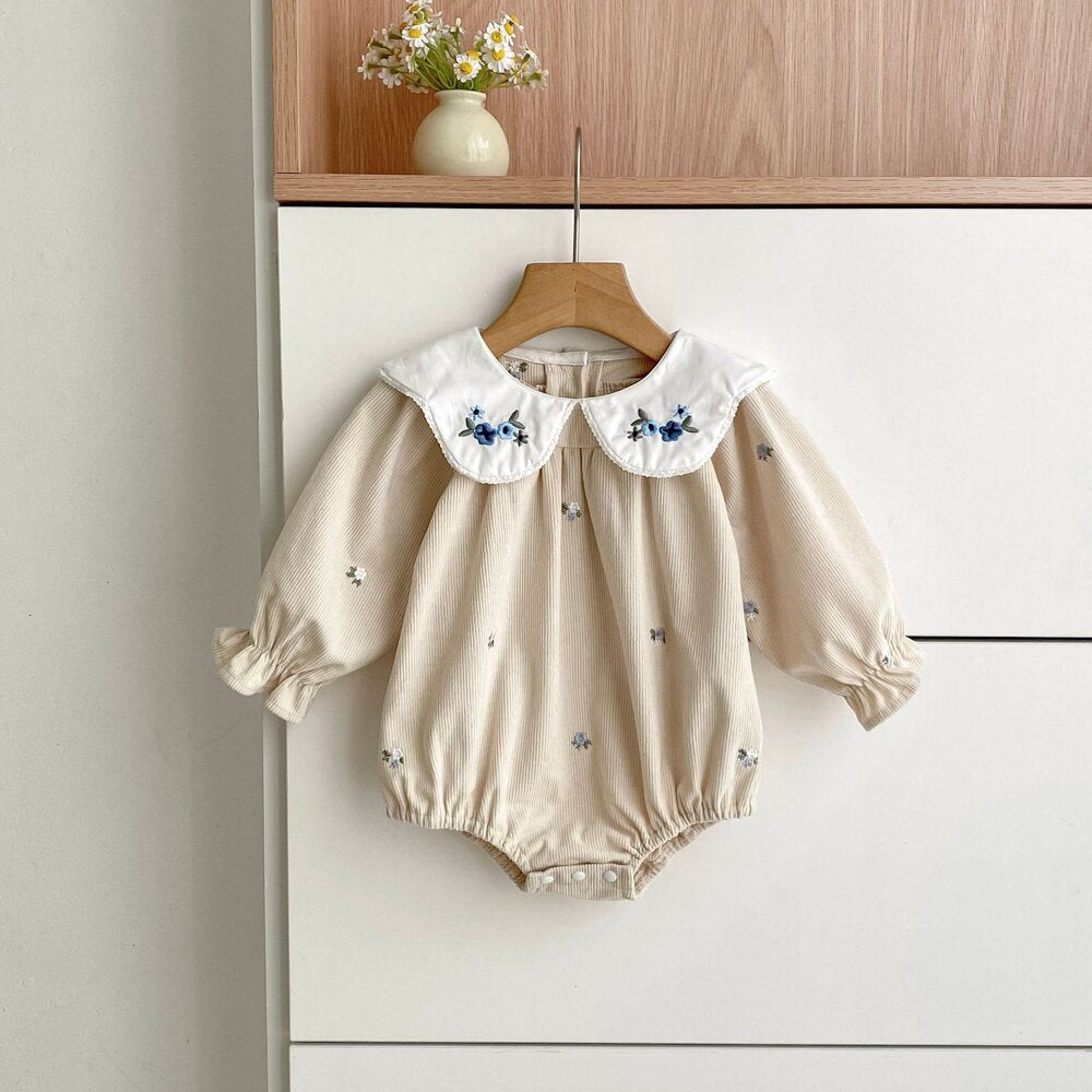 ベビー用長袖ロンパース、アイボリー、白いフリル襟、青い花刺繍の総柄