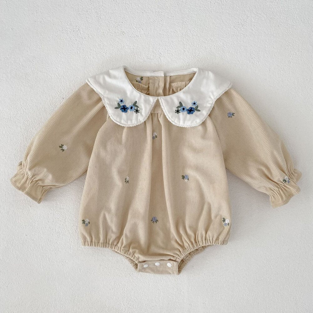 アプリコット色のワンピ風ロンパース、白い丸襟とブルー花刺繍