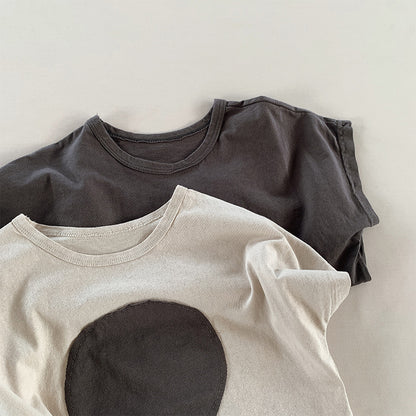 2色のキッズ半袖Tシャツ、丸パッチのデザイン（ベージュとチャコール）