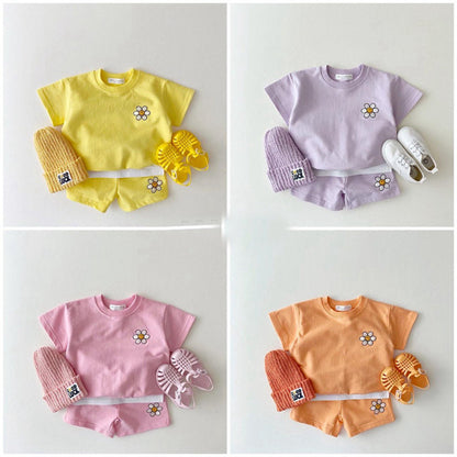 イエローの半袖Tシャツとショートパンツセット、花モチーフのワンポイント