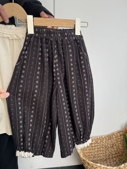 黒のドット柄ワイドロングパンツ、総柄刺繍と裾フリル