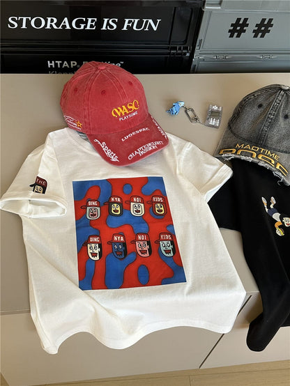 白のキャラクター柄半袖Tシャツ、青赤の矩形キャラプリント