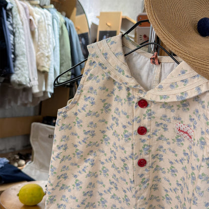 ベージュ花柄サロペットの全体、前ボタンと胸の赤い刺繍パッチ