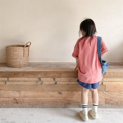 ピンクの半袖Tシャツを着た子どもの後ろ姿