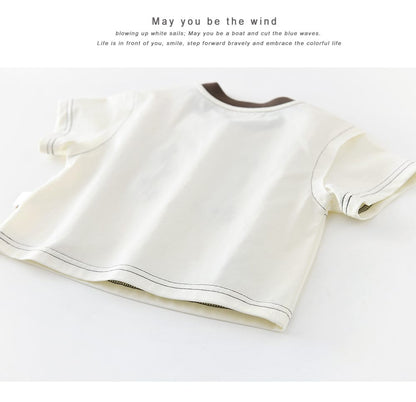 白い半袖Tシャツの背面寄り。ブラウンの丸首リブと裾のステッチライン