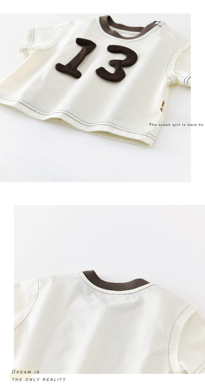 白い半袖Tシャツ前面。数字13の立体パッチとブラウンの丸首リブ