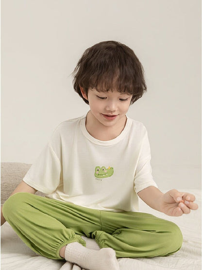 子ども用パジャマ上下セット、白Tシャツとグリーンパンツ、恐竜プリントのアップ
