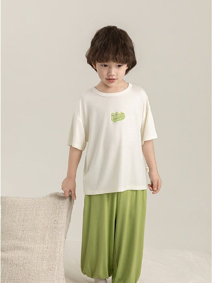 子ども用パジャマ上下セット、白Tシャツとグリーンパンツ、フロントに恐竜プリント