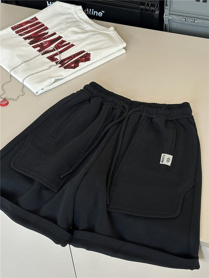 黒のスウェットハーフパンツ、ドローストリングとパッチポケット付き