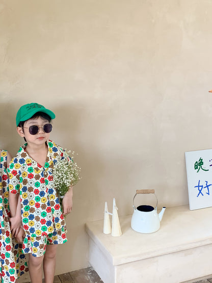 カラフル花柄の子ども用セットアップ、緑キャップ姿