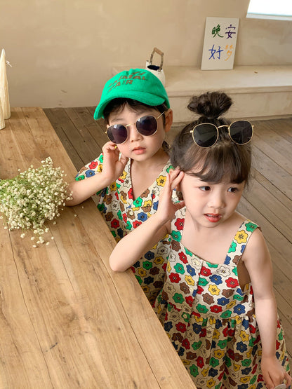カラフル花柄の子ども用ワンピース、緑キャップとサングラス