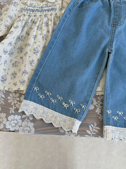 ブルーのワイドデニムパンツ裾アップ。刺繍モチーフのラインとレーストリム