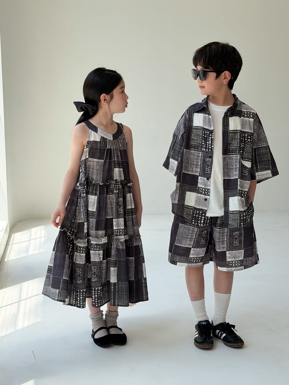 幾何学柄のノースリーブワンピースと半袖シャツハーフパンツセット（横姿）