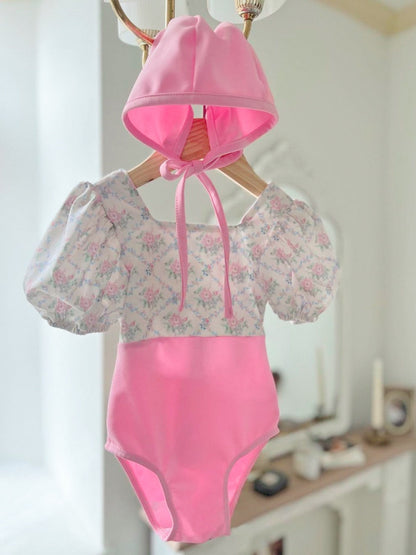ピンクのフローラル柄ワンピース水着、リボン結びとフリル袖