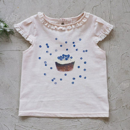 ピンクベージュのフリル袖Tシャツ、青いドットとカップケーキプリント