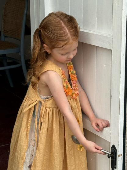 金色のノースリーブワンピース、Vネックのギャザーと立体フラワー装飾