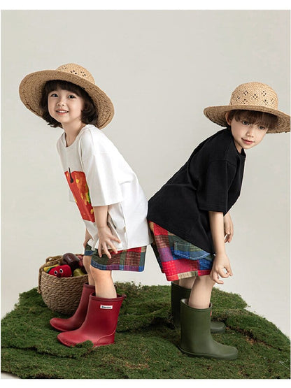 白Tシャツと黒Tシャツのフルーツ柄プリント。子ども2人がポーズ。