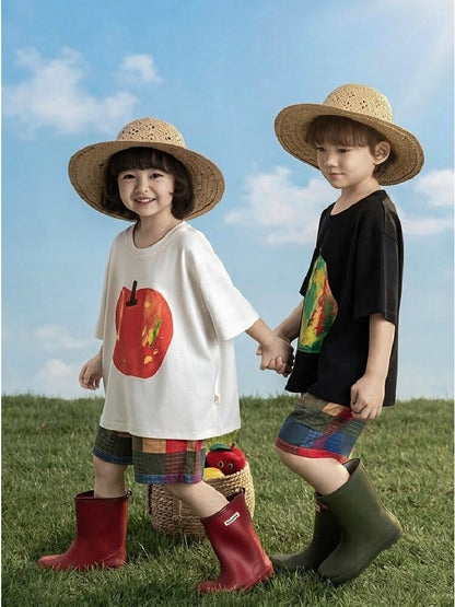 白Tシャツと黒Tシャツのフルーツ柄プリント。子どもが横向きで着用。