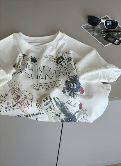 クリーム色の半袖Tシャツ、前面に大きな落書き風プリント