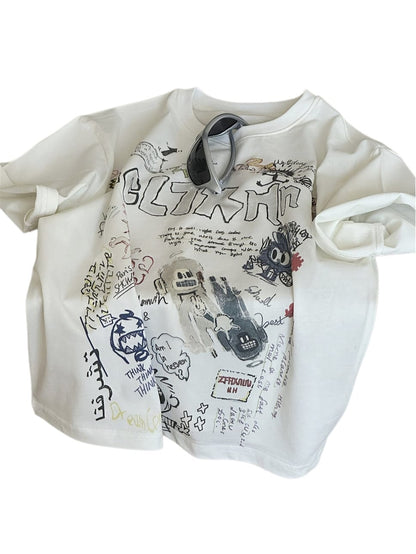 クリーム色半袖Tシャツ、タグ風文字やキャラクターのグラフィックプリント
